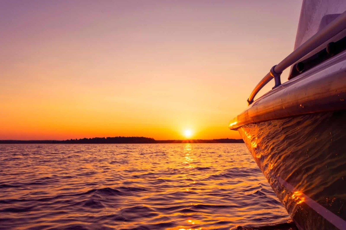 A view of an ocean sunset from the side of a boat